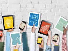 Group of Hands Holding Digital Devices with Startup Concept